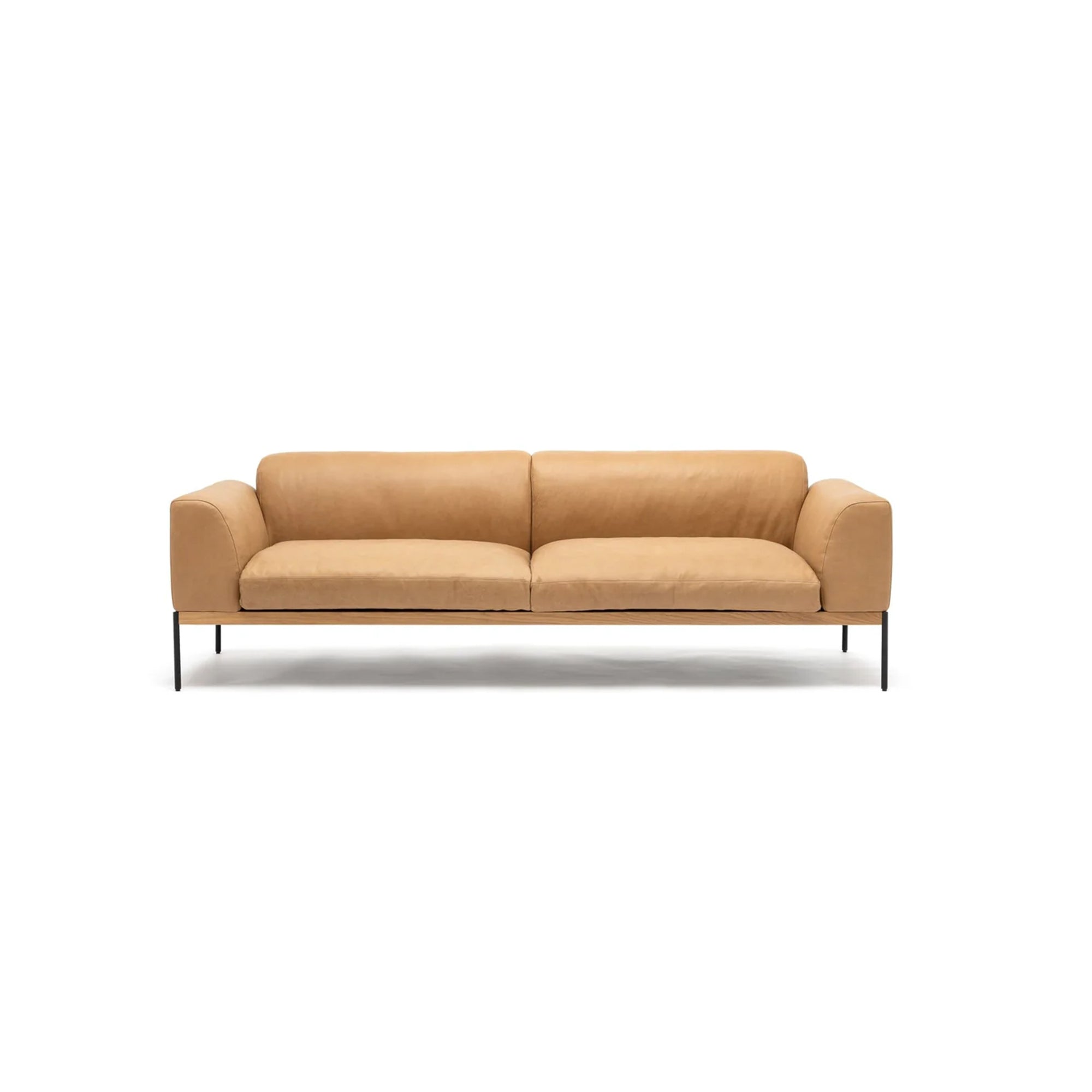 The Department Sofa 93" | Leather by Wooden Stories features wide cushions, a low back, and armrests in tan leather, with slim black metal legs and an FSC-certified oak base, shown against a plain white background.
