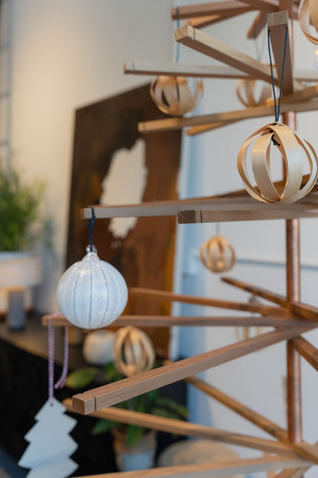 The SOBU Immortal Christmas Tree, crafted from recycled wood and decorated with wooden ornaments, a white bauble, and a tree-shaped ornament, offers a stylish and sustainable touch to your modern indoor Christmas celebration.