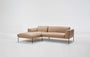 The Department Modular Sofa | Leather • M1 Left by Wooden Stories features a modern beige L-shape, low solid wood base, and slim black metal legs, inspired by Danish design, set against a plain white background.