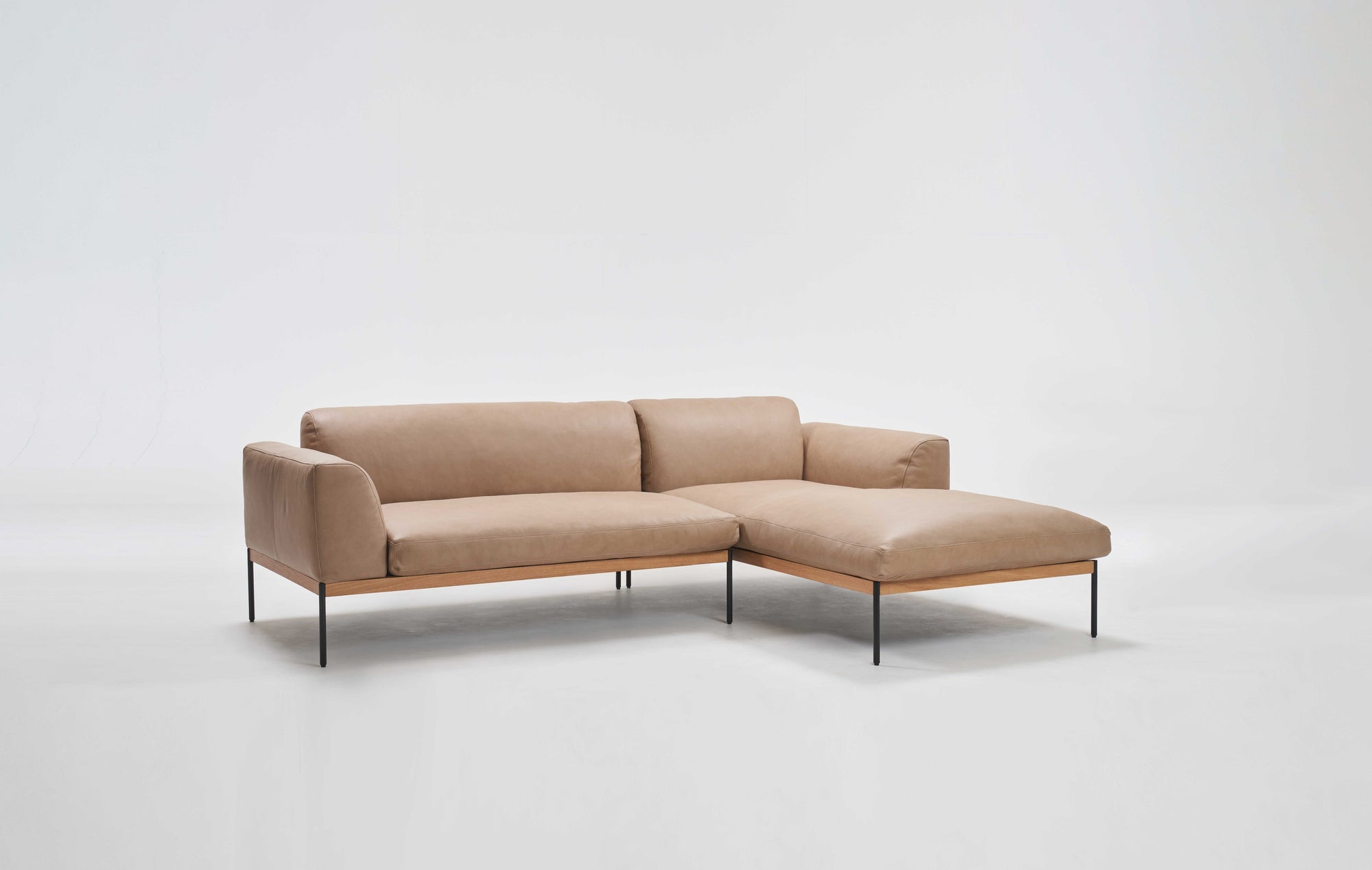 The Wooden Stories Department Modular Sofa | Leather • M1 Right is a modern beige L-shaped sectional with minimalist metal legs and low backrests, shown against a plain white background.