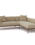 The Wooden Stories Department Modular Sofa | Fabric • M5 Right, a modern L-shaped beige sectional with metal legs and two matching cushions, inspired by Danish collections, is set against a plain white background.