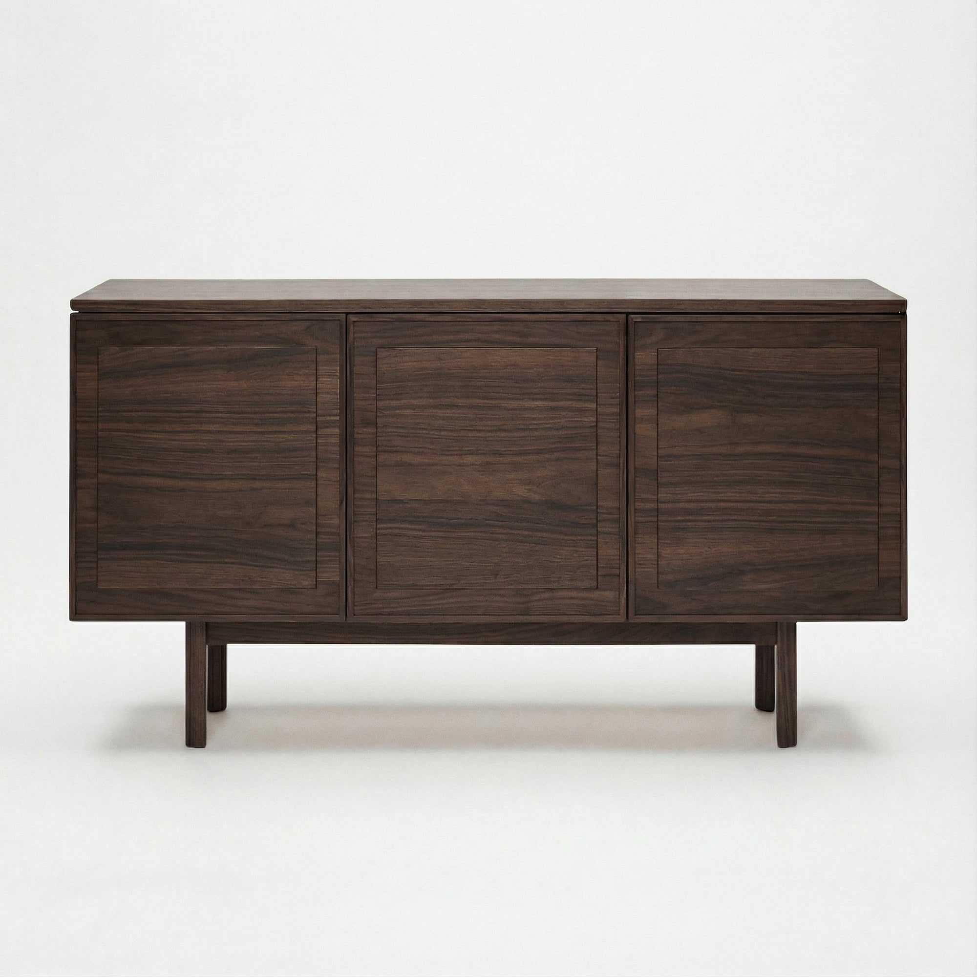 The Yorke Sideboard by Wooden Stories is a modern, dark wood piece with three rectangular cabinet doors, Danish lines, and clean edges in a minimalist design, shown against a plain white background.