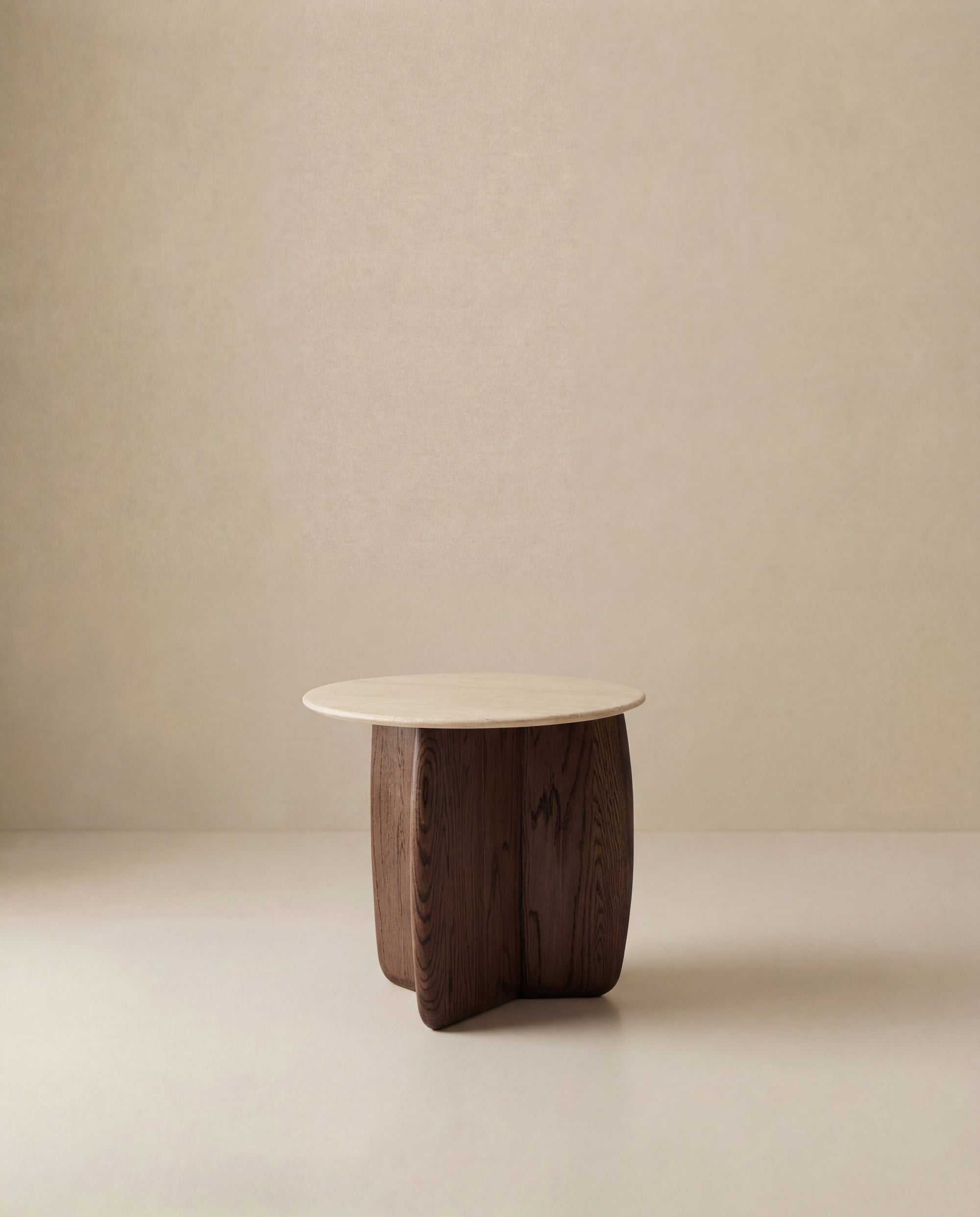 The Eden Side Table | Stone Top by Wooden Stories features a minimalist, modern design with a light stone top and sculptural dark wood base, highlighting Scandinavian simplicity against a plain beige background.