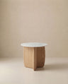The Eden Side Table | Stone Top by Wooden Stories features a white marble top and light American oak base with intersecting curved panels, embodying Scandinavian simplicity against a beige backdrop.