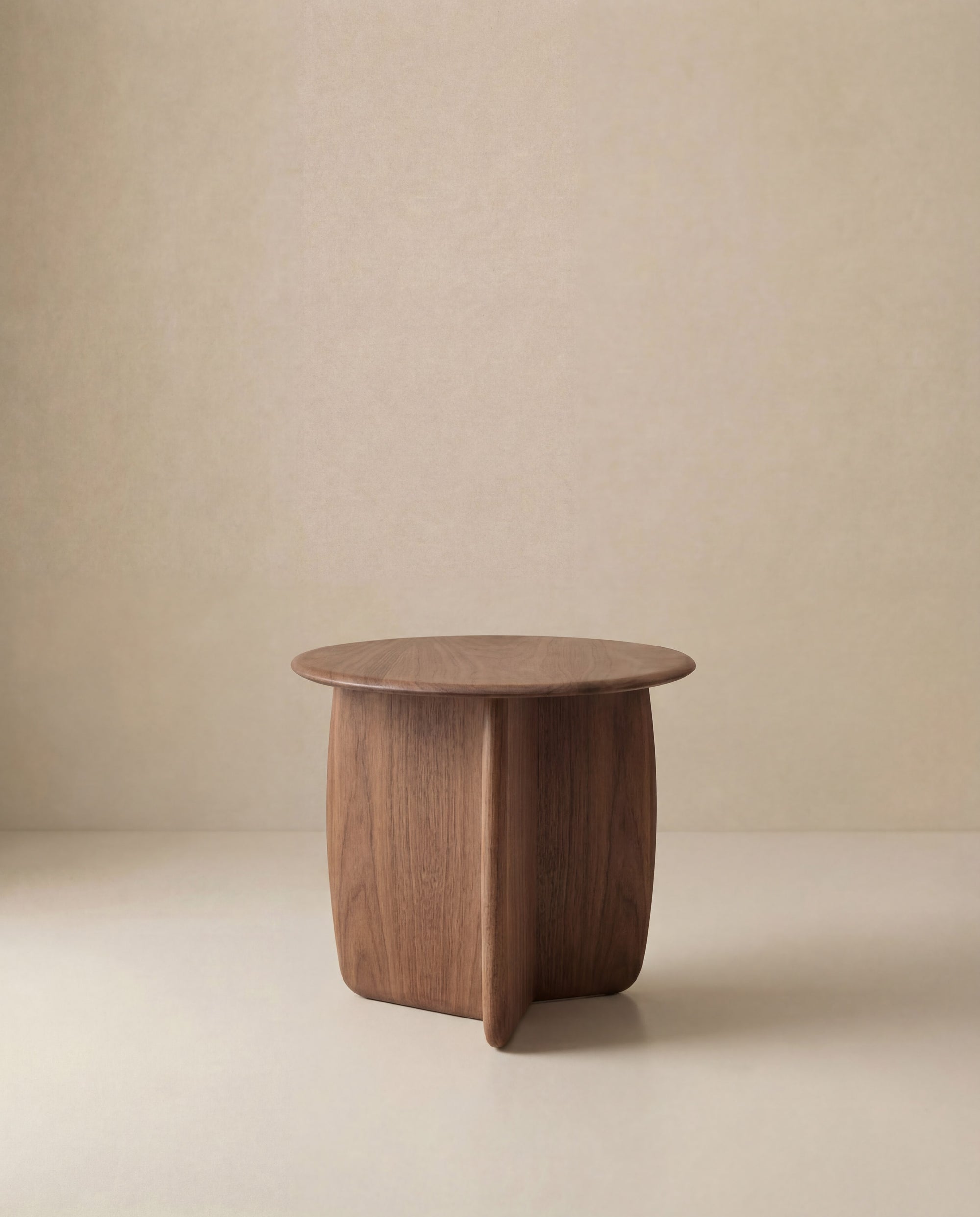 The Eden Side Table by Wooden Stories, crafted from American oak, features a smooth surface, curved edges, and intersecting panels in a simple Scandinavian design. Set against a beige minimalist background.