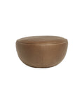 The Fable Ottoman | Leather by Wooden Stories is a round, brown ottoman with smooth leather upholstery and a gently flattened top, inspired by modern Danish design, shown against a plain white background.