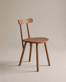 The Figura Dining Chair | Latte Oak by Wooden Stories features a simple wooden design with a round seat, straight legs, and a horizontal backrest, set against a neutral beige background.