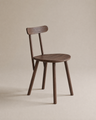 The Figura Dining Chair by Wooden Stories features an espresso oak finish, a round seat, four straight legs, and a curved backrest, shown against a plain beige background.