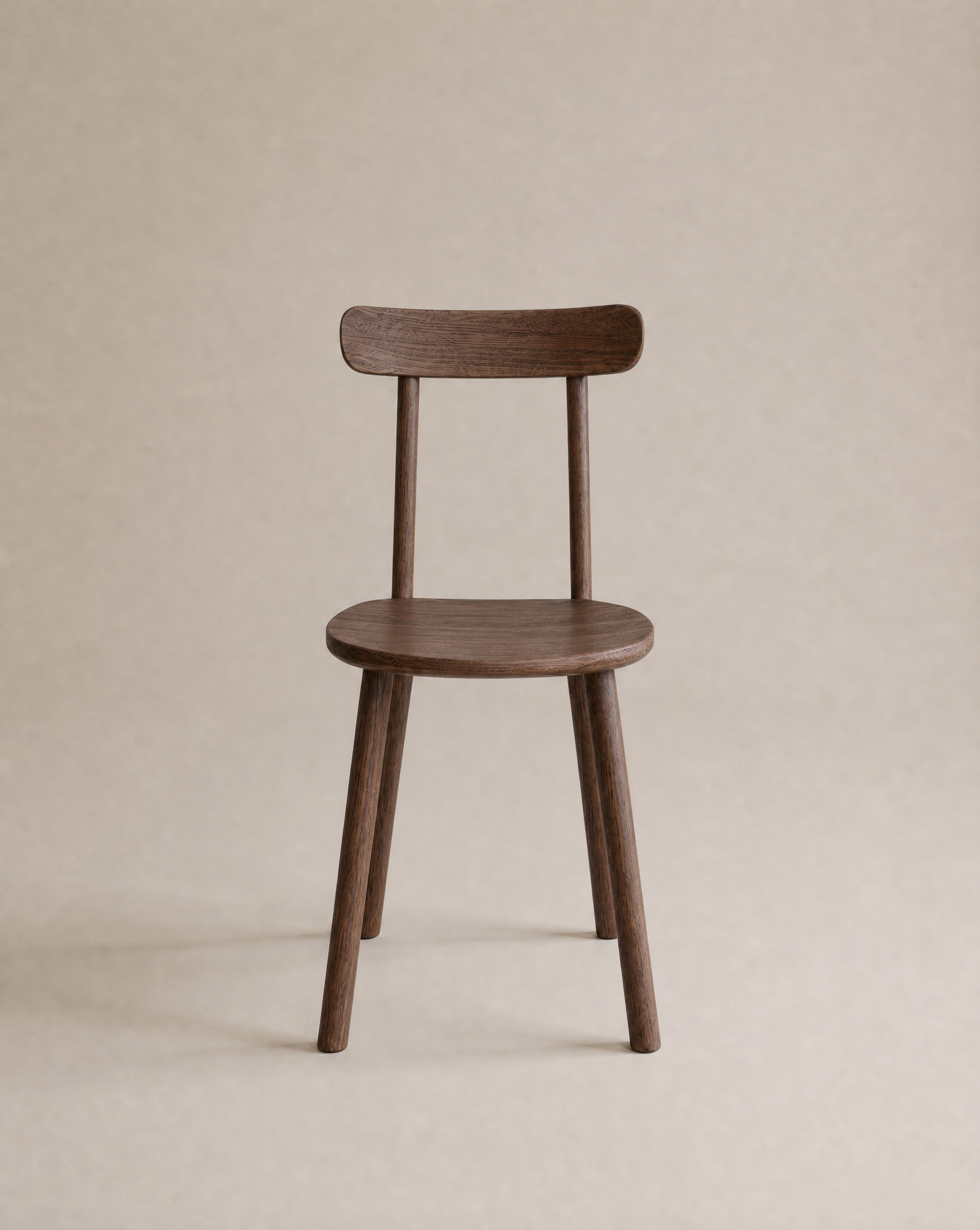 The Figura Dining Chair by Wooden Stories features a minimalist, modern design with a curved backrest, espresso oak finish, and contract grade durability, set against a neutral beige background.