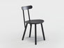 The Figura Dining Chair by Wooden Stories features a minimalist black oak design with three legs, a round seat, and a slim backrest bar, inspired by heritage woodworking, shown against a plain white background.