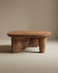 The SOBU Nick Coffee Table features a handcrafted oval top and sculptural base made from solid Acacia wood, set against a neutral background.