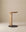The Guild Side Table by Wooden Stories features a minimalist design with a solid oak round top, single vertical leg, and flat black circular base, shown against a plain beige background.