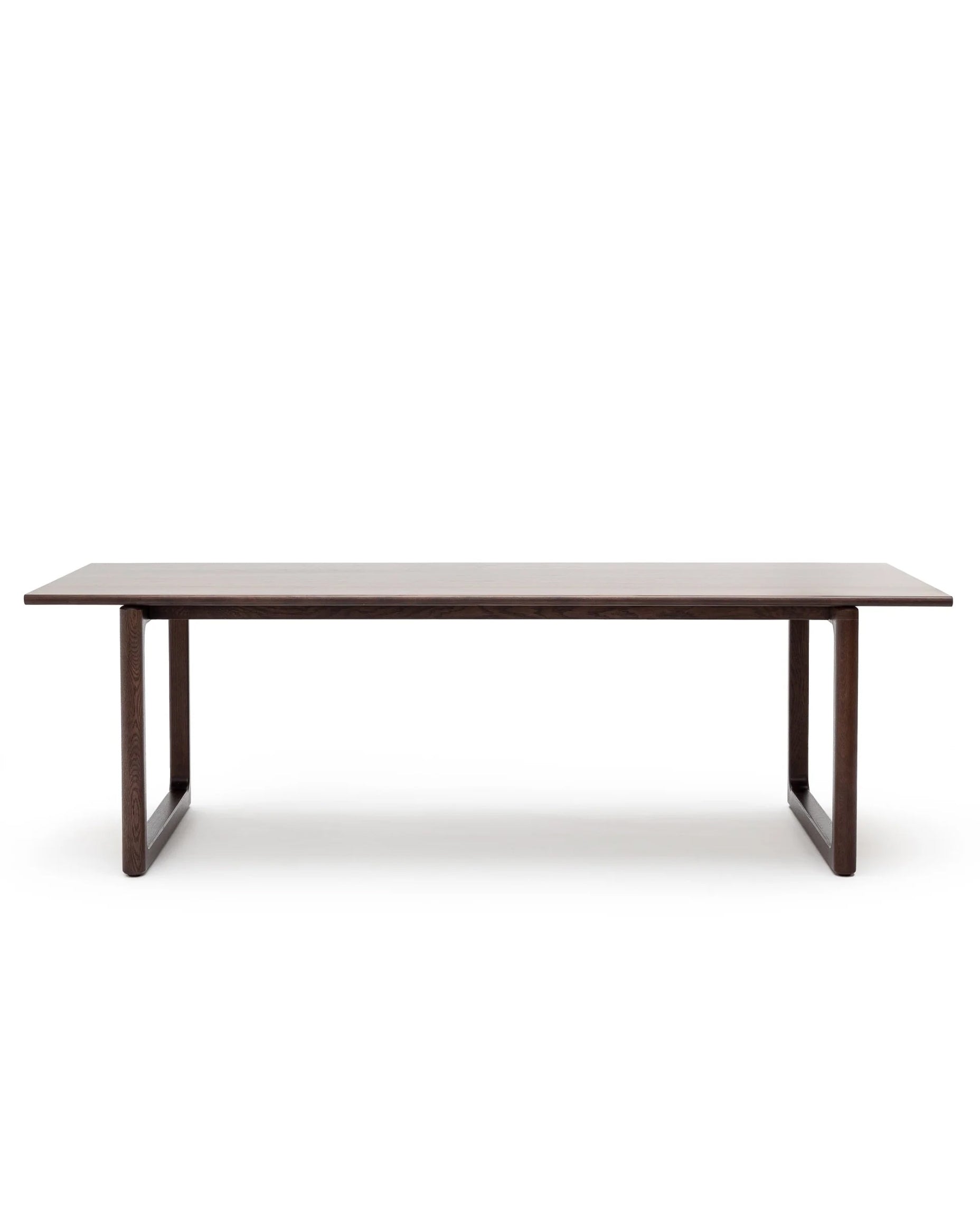 The Hover Dining Table | Espresso Oak by Wooden Stories is a minimalist, rectangular solid oak table with a dark brown finish and sturdy open-base legs, shown against a plain white background.