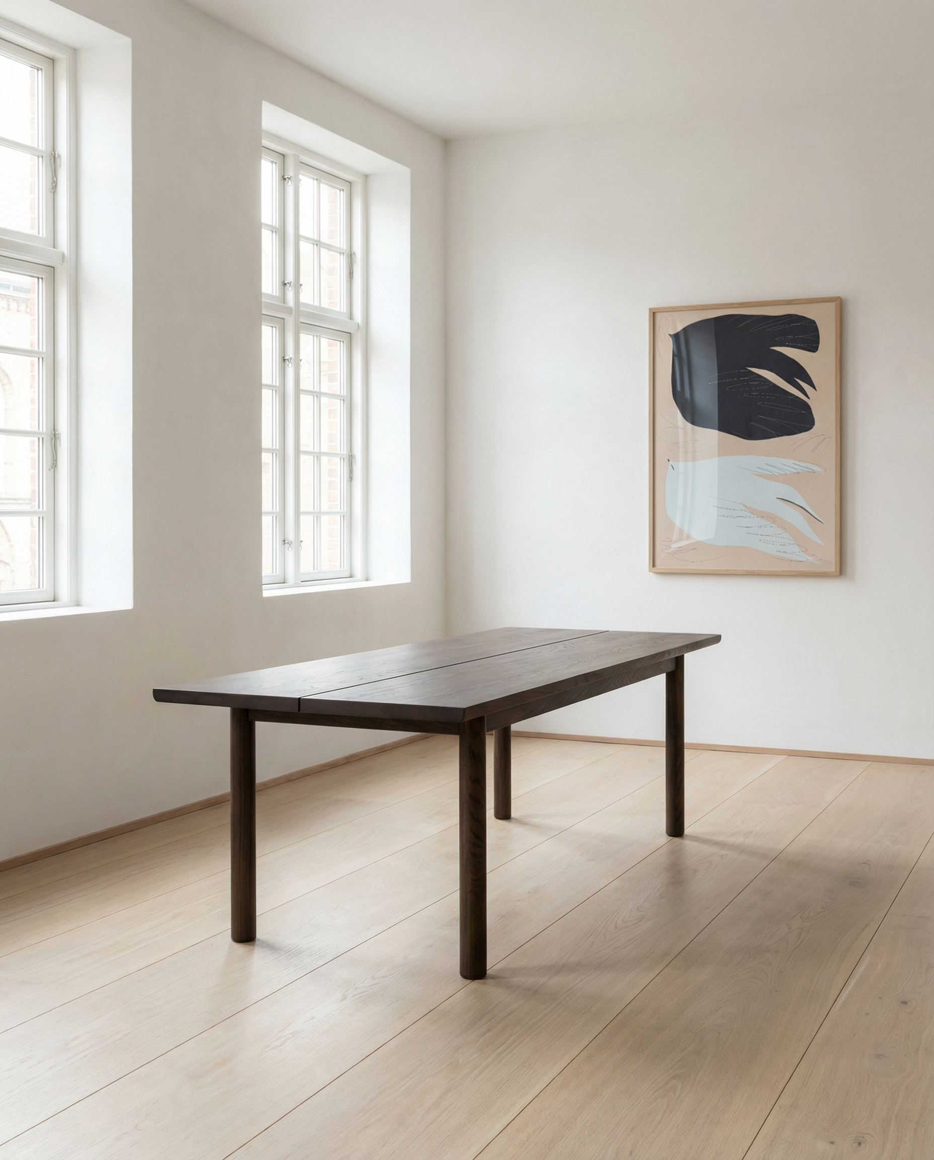 A minimalist room with large windows, light wood floors, an Espresso Oak Itamae Dining Table by Wooden Stories, and abstract wall art. Scandinavian design elements create a bright, uncluttered atmosphere.