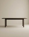 The Wooden Stories Itamae Dining Table in Espresso Oak features a minimalist Scandinavian design with four sturdy legs, crafted from solid oak, and is displayed against a plain light beige background.