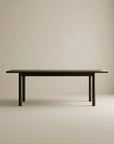 The Wooden Stories Itamae Dining Table in Espresso Oak features a minimalist Scandinavian design with four sturdy legs, crafted from solid oak, and is displayed against a plain light beige background.