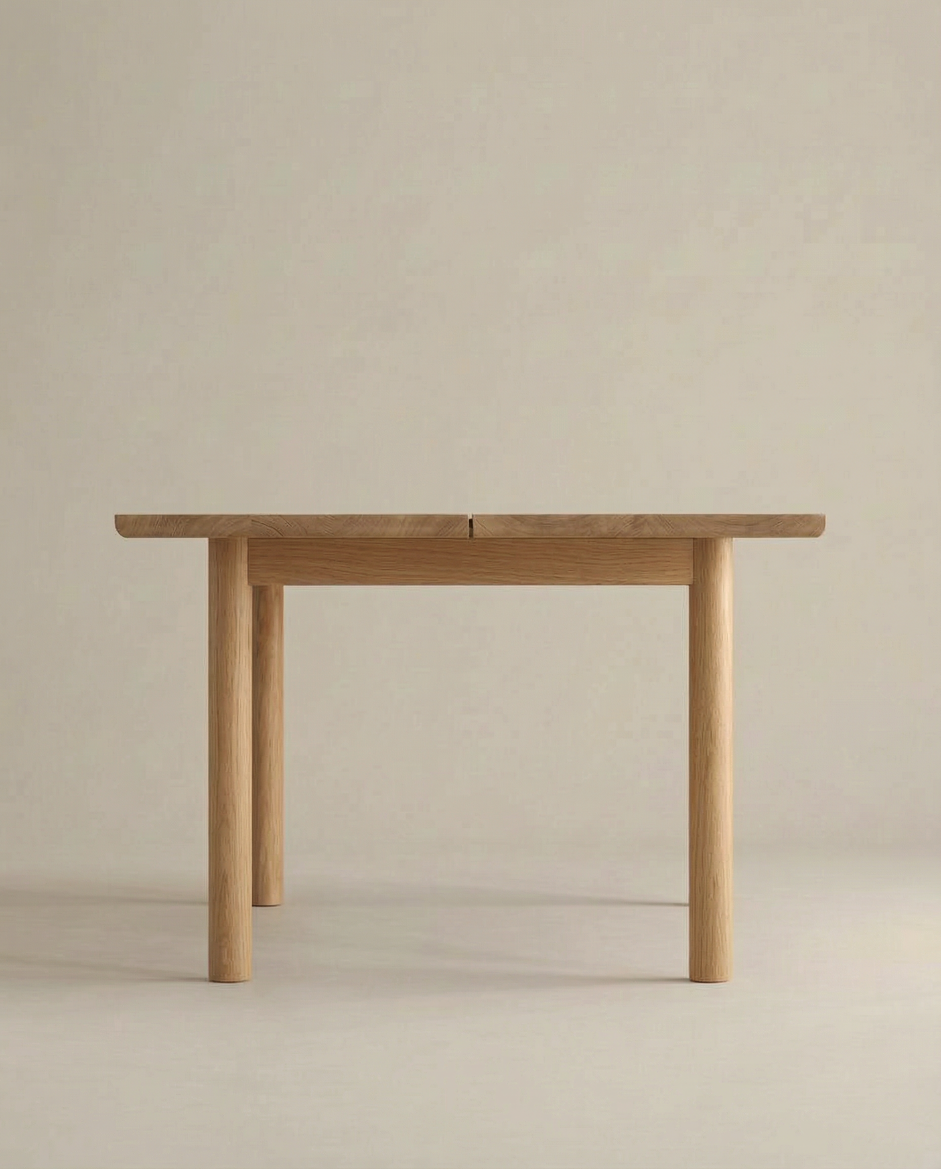 The Wooden Stories Itamae Dining Table in Light Oak is a rectangular, minimalist Scandinavian-style table with four sturdy, round legs, photographed against a plain beige background.