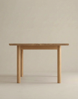 The Wooden Stories Itamae Dining Table in Light Oak is a rectangular, minimalist Scandinavian-style table with four sturdy, round legs, photographed against a plain beige background.