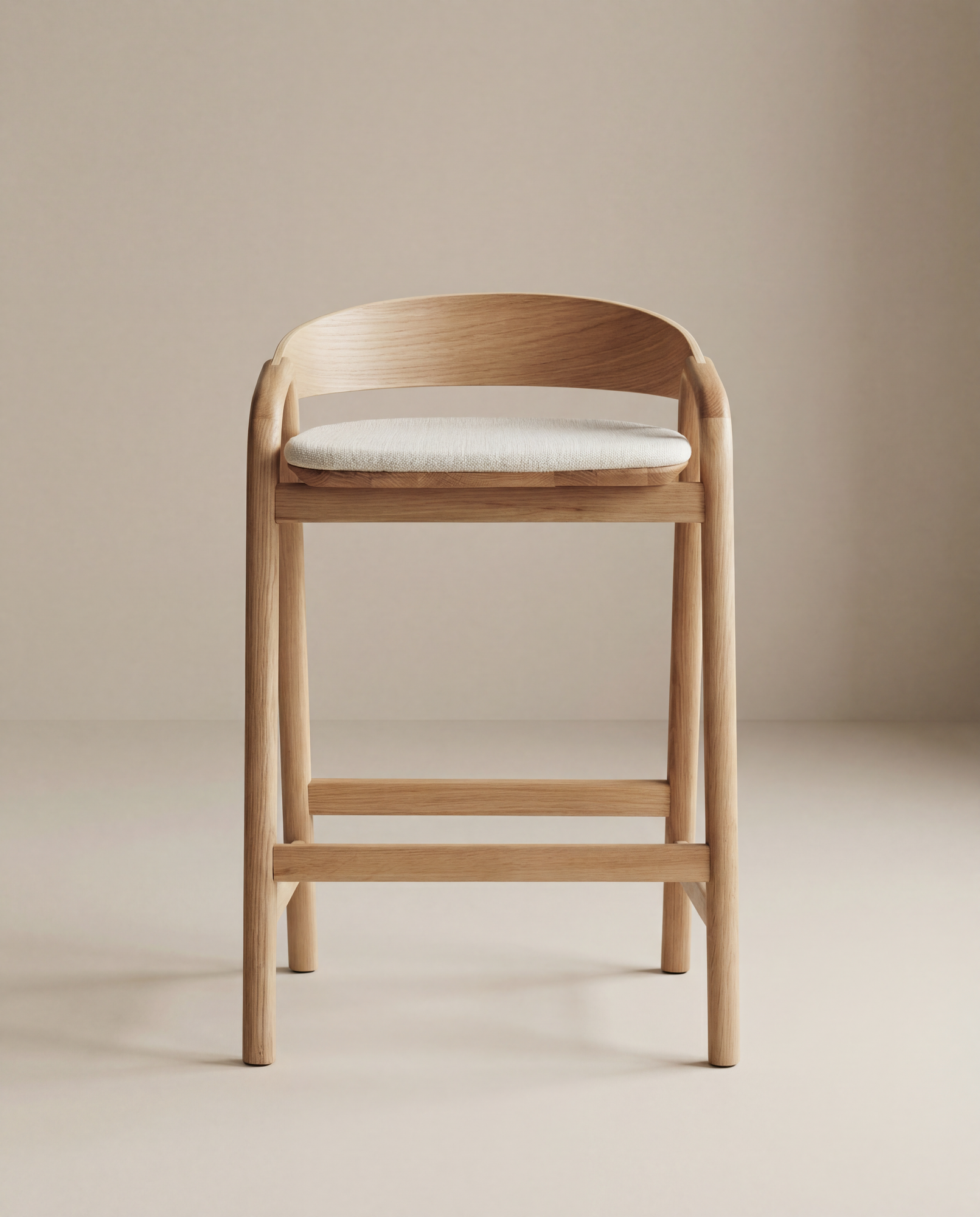 The Inlay Counter Stool | Fabric Seat by Wooden Stories features solid oak, a curved backrest, and a light fabric seat, styled against a neutral beige background.