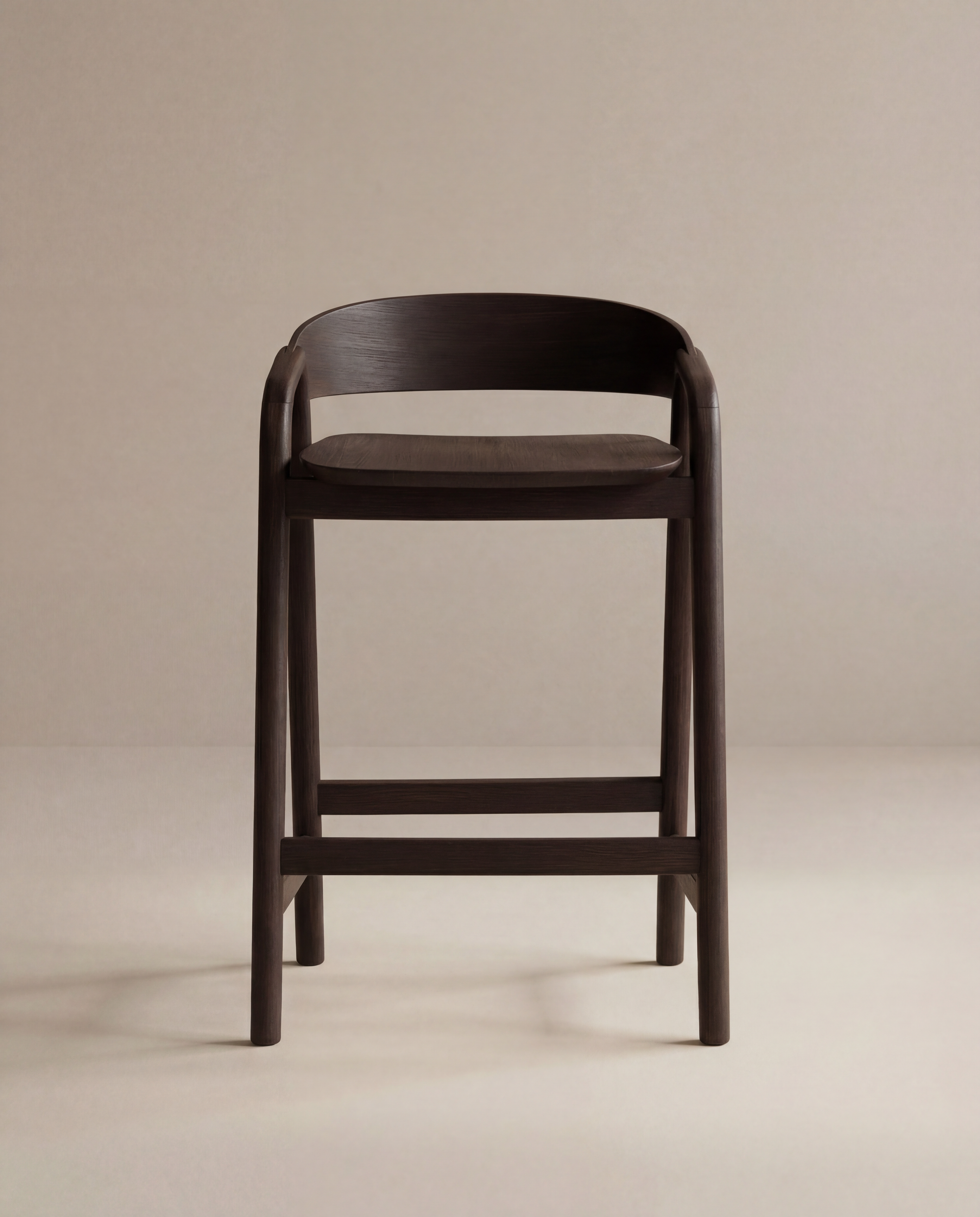 The Inlay Counter Stool | Wood Seat by Wooden Stories features modern Danish design in dark wood with a curved backrest and footrest, ideal for stylish kitchen island seating, shown here on a plain beige background.