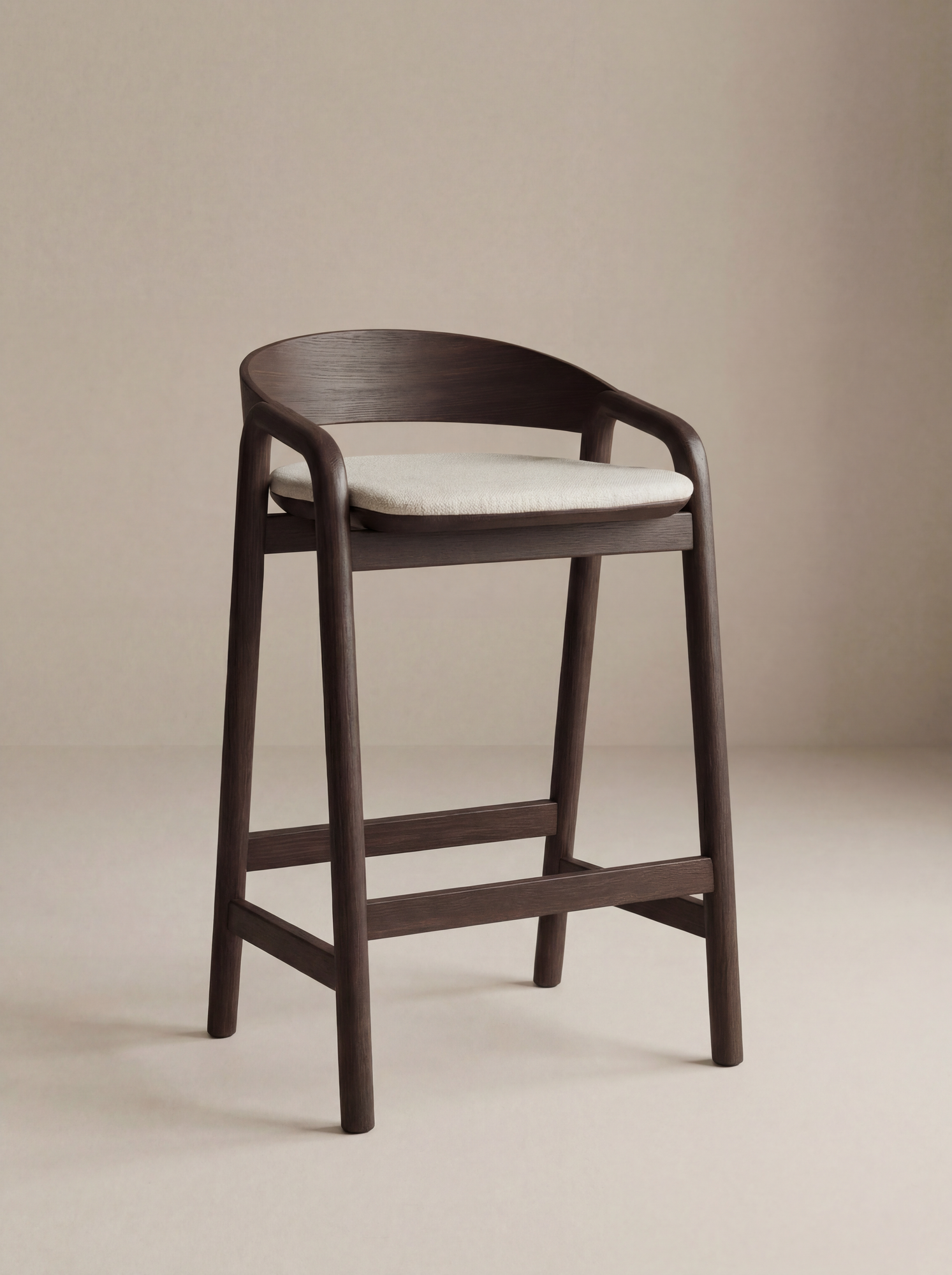 The Inlay Counter Stool | Fabric Seat by Wooden Stories features a curved solid oak frame and a light cushioned seat, shown against a plain beige background.