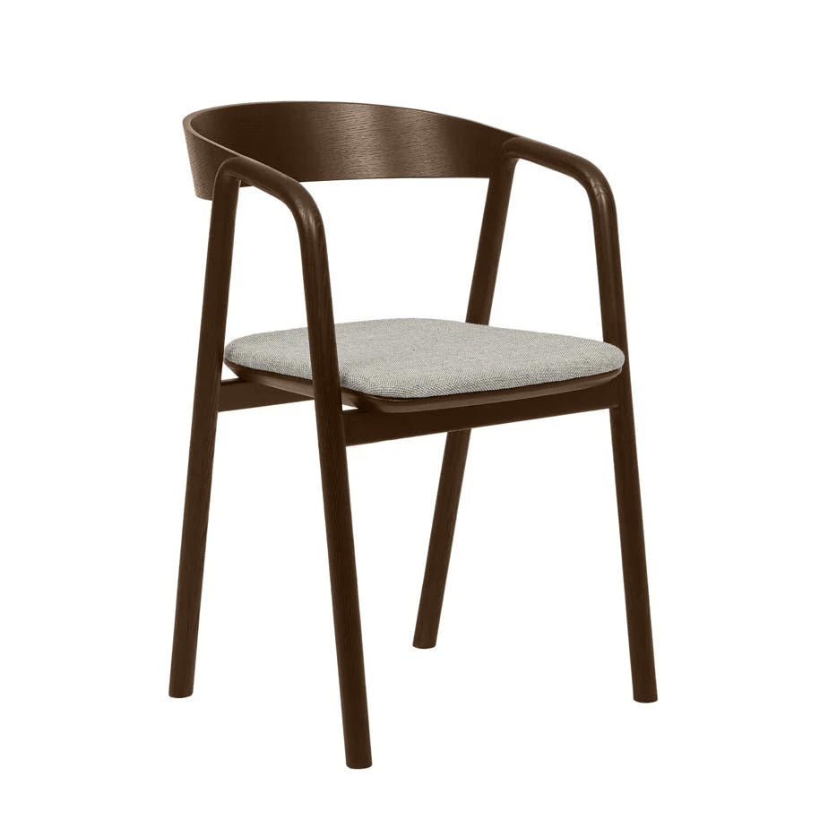 The Inlay Dining Chair by Wooden Stories features a curved backrest, angled legs, and a light gray cushioned seat. Crafted from espresso oak, this modern piece blends minimalist style with contemporary Danish design.