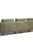 The Islet Sofa | Fabric by Wooden Stories is a green, modern piece featuring three back cushions and wooden legs, shown from the back against a white background.