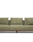 The Islet Sofa | Fabric by Wooden Stories is a modern olive green sofa with three seat cushions, four matching backrest cushions, and a wooden base, displayed against a plain white background.