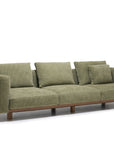 The Islet Sofa | Fabric by Wooden Stories is a modern olive green sofa featuring three seat cushions, four backrest pillows, wide armrests, and a wooden base, shown against a white background.