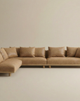 The Islet Modular Sofa | Leather • M2 by Wooden Stories is a large, modern L-shaped tan leather sectional with seven matching back cushions, clean lines, and low wooden legs, set against a plain beige background.