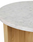 The Pivot Side Table | Light Oak by Wooden Stories features a round white marble top with subtle grey veining, resting on a light solid wood cylindrical base, inspired by Danish design with only the table edge and upper base visible.