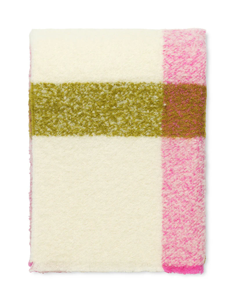 The Elvang Denmark Lava Throw - Pink, featuring a soft bouclé texture with a wide olive green horizontal stripe and a pink vertical stripe near one edge, is displayed folded on a white background.
