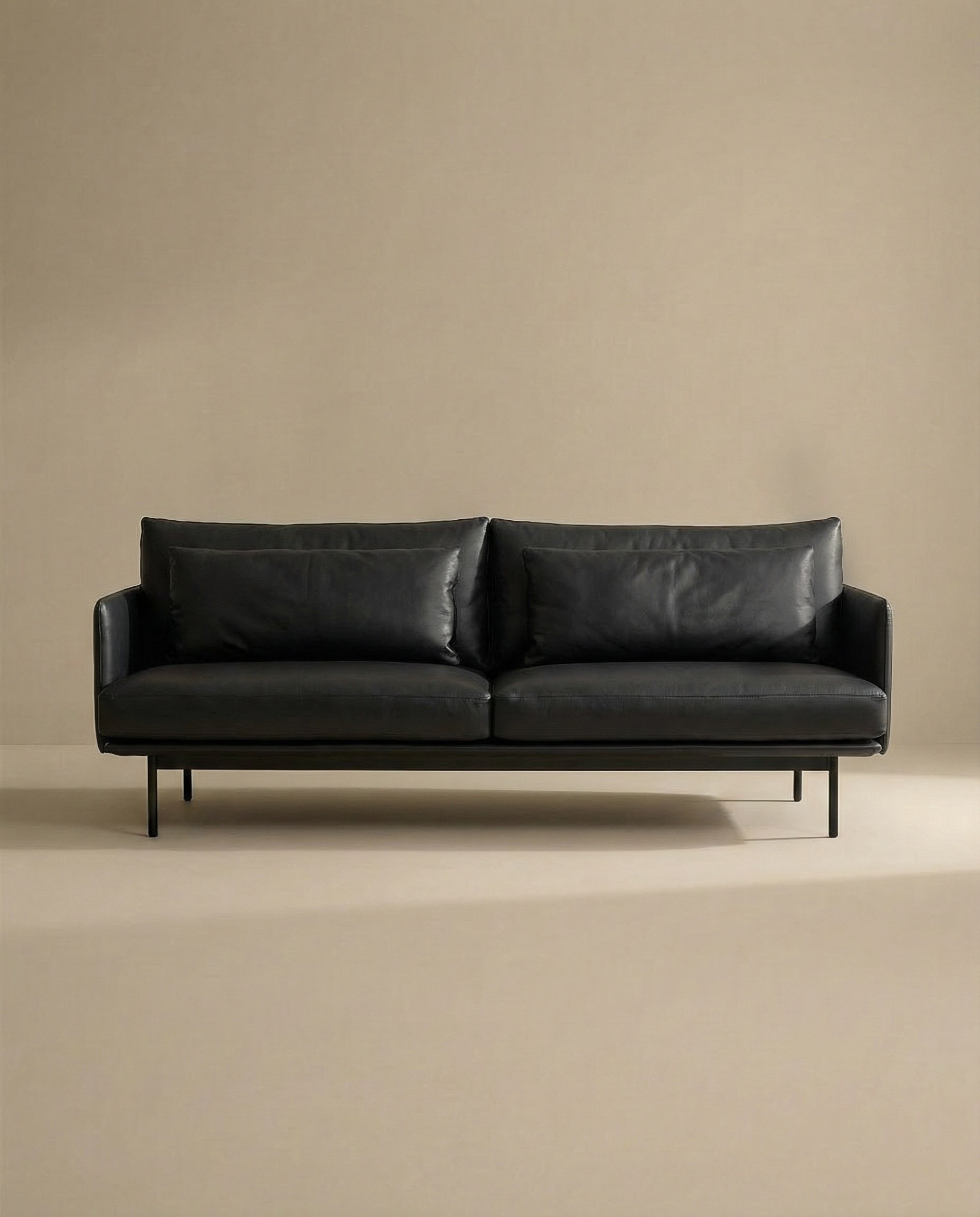 The SOBU Cherry Sofa | Leather, a modern black 3-seater with slim arms and metal legs, brings Danish-inspired style to any living space, shown centered against a plain beige background.