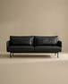The SOBU Cherry Sofa | Leather, a modern black 3-seater with slim arms and metal legs, brings Danish-inspired style to any living space, shown centered against a plain beige background.