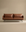 A modern Cherry Sofa | Leather by Wooden Stories, featuring rich brown leather upholstery and sleek metal legs, sits against a plain beige background. The minimalist design boasts two seat cushions and two back cushions, creating a clean, stylish look that ensures exceptional comfort—making it an ideal choice for any modern living space.