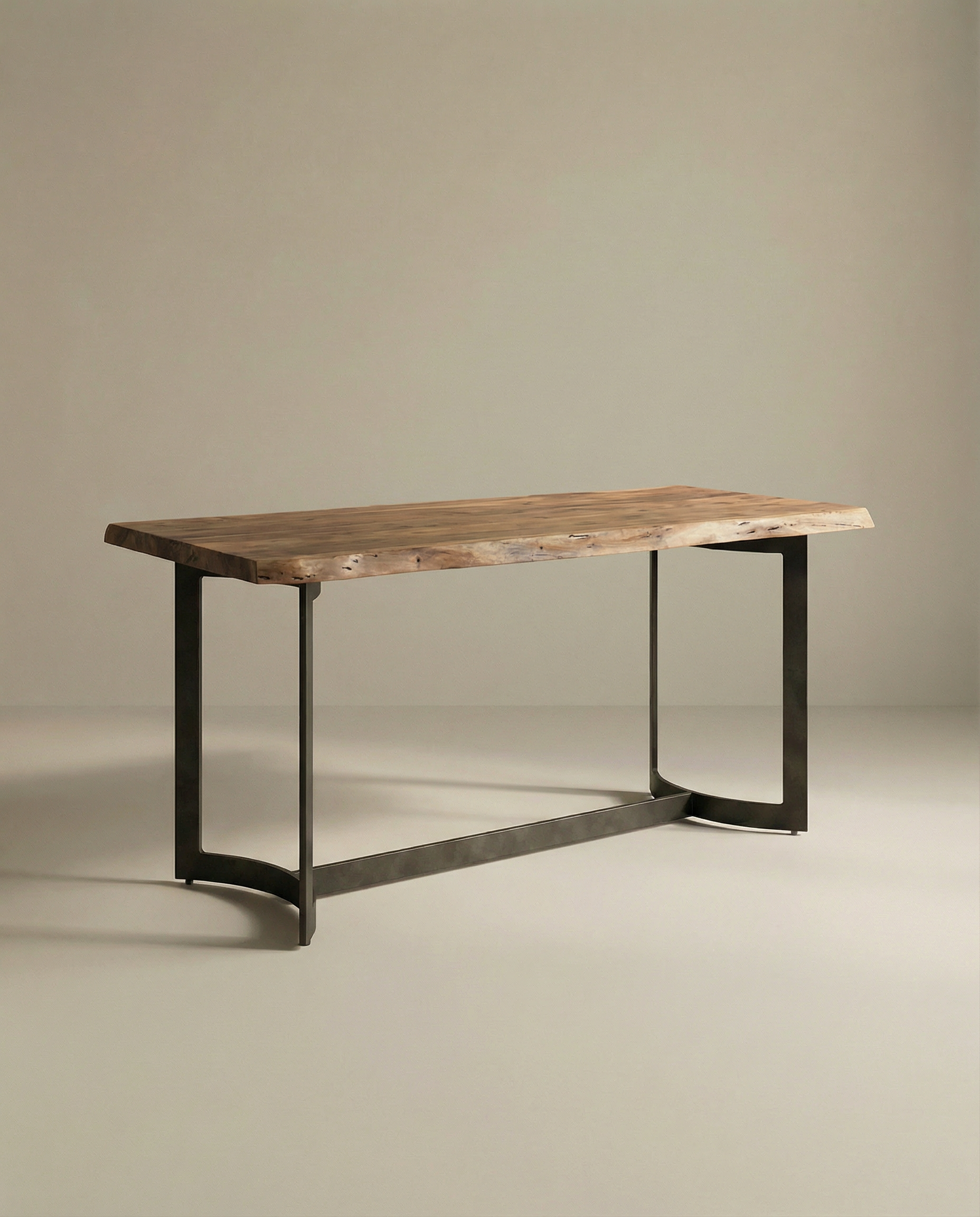 The Moes Leviathan Live Edge Counter Table features a rectangular solid acacia top and a sculptural metal base, displayed against a plain, neutral background.