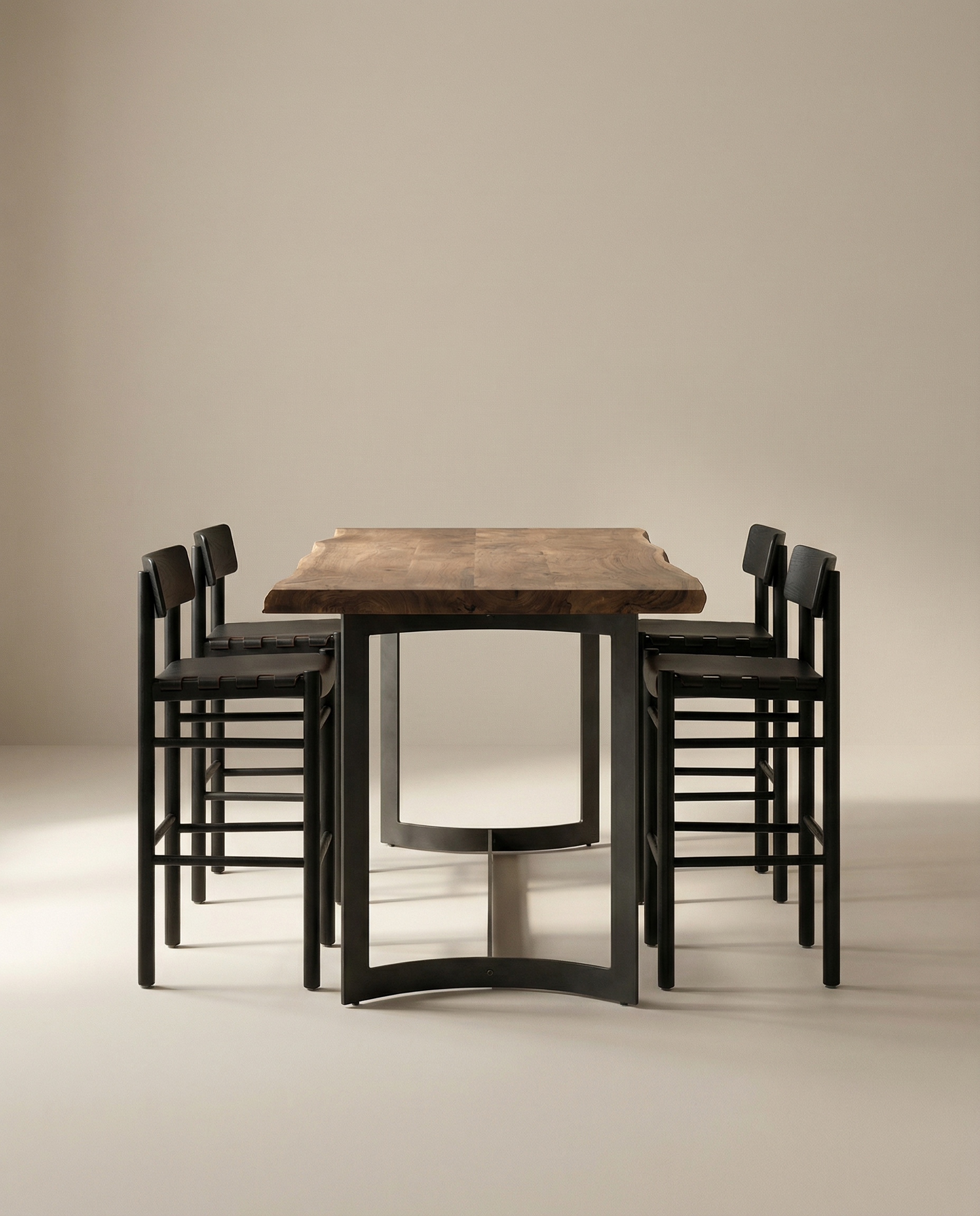 The Moes Leviathan Live Edge Counter Table features a natural slab top and black metal legs, paired with six matching black chairs, all set against a plain beige background.