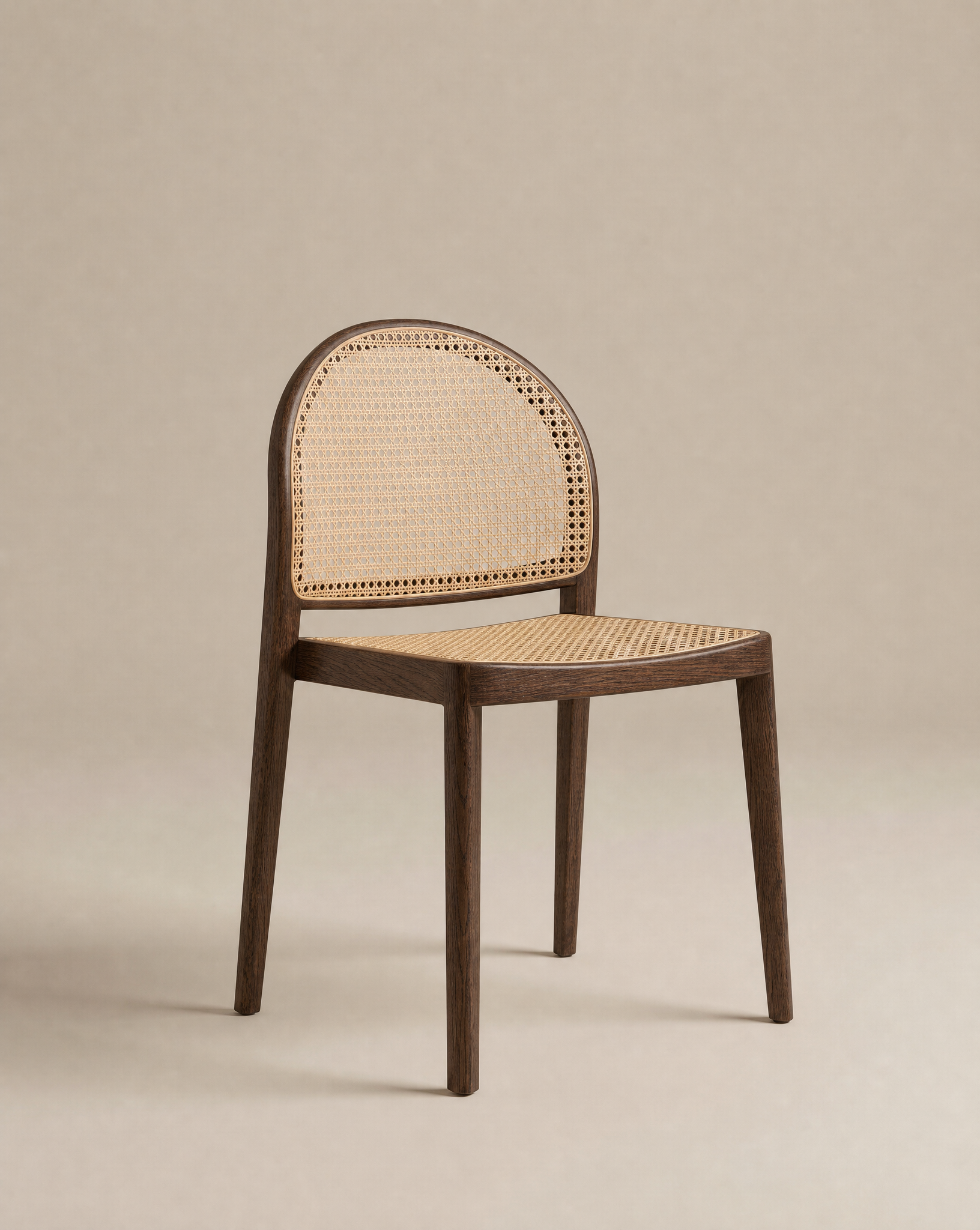 The Luk Dining Chair by Wooden Stories features a wooden arch silhouette, a curved backrest, and a cane weave rattan seat, displayed against a neutral beige background.