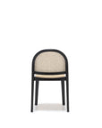 The Luk Dining Chair by Wooden Stories features a rounded backrest, black frame, and cane weave rattan seat and back. Shown on a plain white background, it boasts contract grade construction for lasting durability.