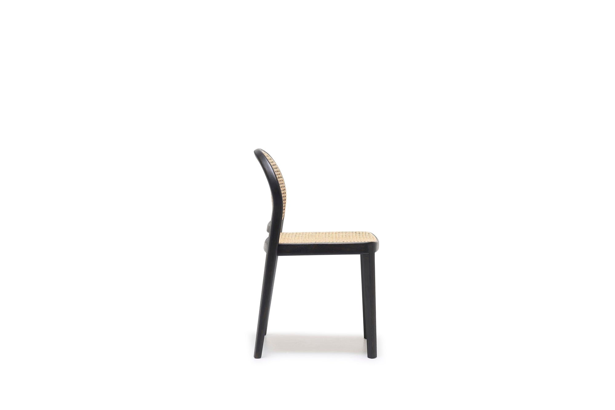 The Luk Dining Chair by Wooden Stories features a wooden frame with a cane weave rattan seat and backrest, shown in a simple side view against a plain white background.