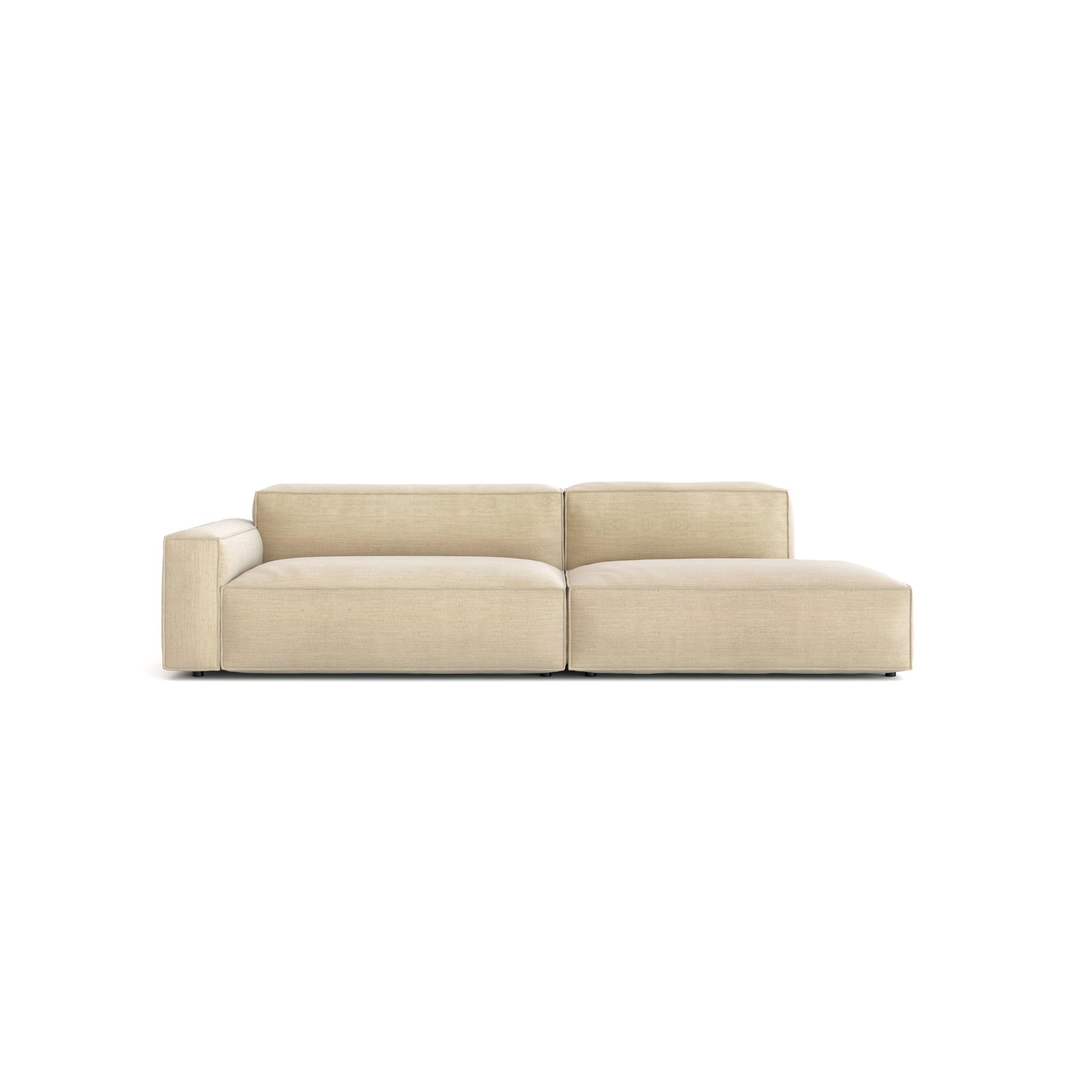 The Baker Modular Sofa | Fabric • M2 by Wooden Stories is a modern light beige sofa with clean lines, one left armrest, and a right-side chaise lounge, shown against a white background.