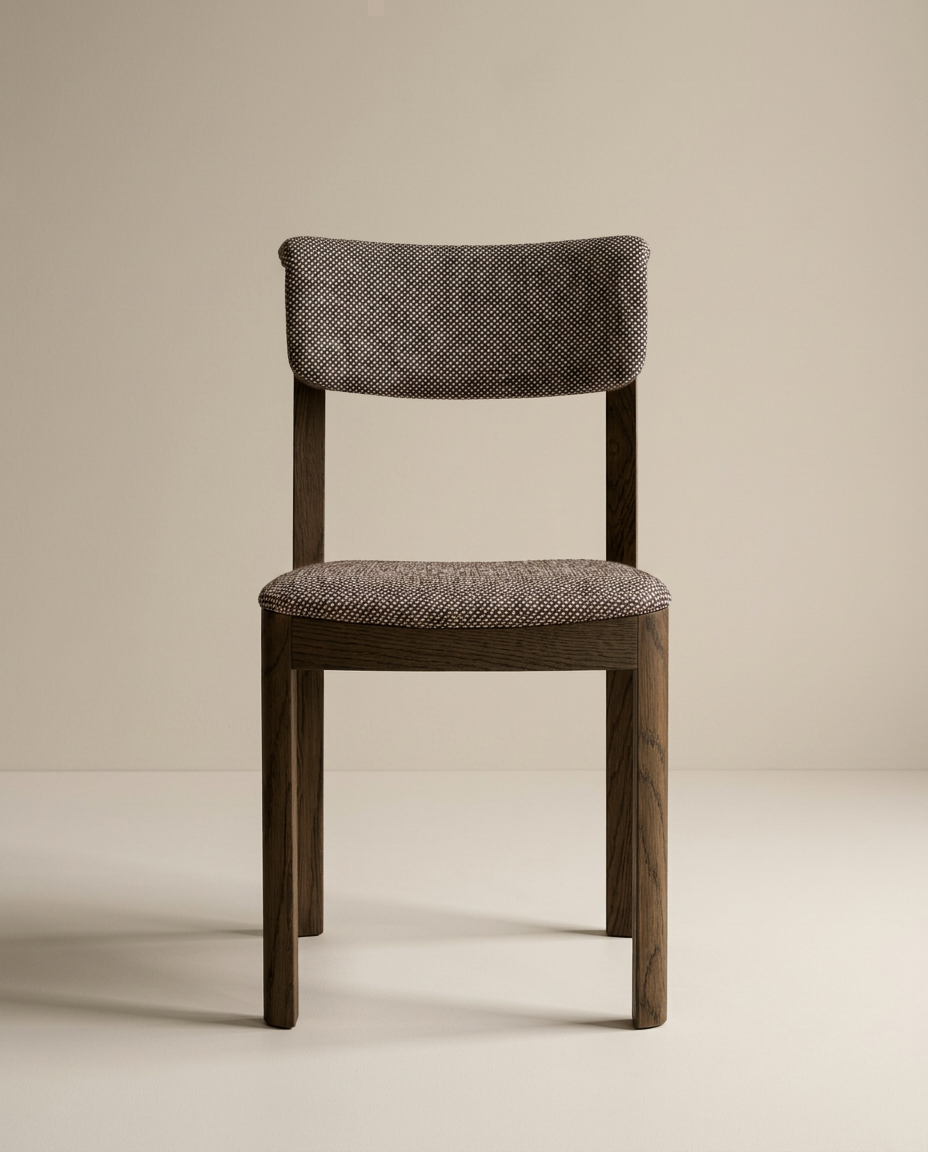 The Wooden Stories Noki Dining Chair features an espresso oak frame with cushioned seat and backrest in textured grayish fabric, shown against a plain beige background.