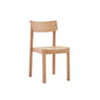 The Wooden Stories Noki Dining Chair in Light Oak features a curved backrest and flat seat, crafted from solid wood, and is shown against a plain white background.