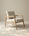 The Nysse Lounge Chair | Fabric by Wooden Stories, crafted from solid oak with light beige cushions, sits in a softly lit room, reflecting a minimalist and calming Scandinavian lounge chair aesthetic.