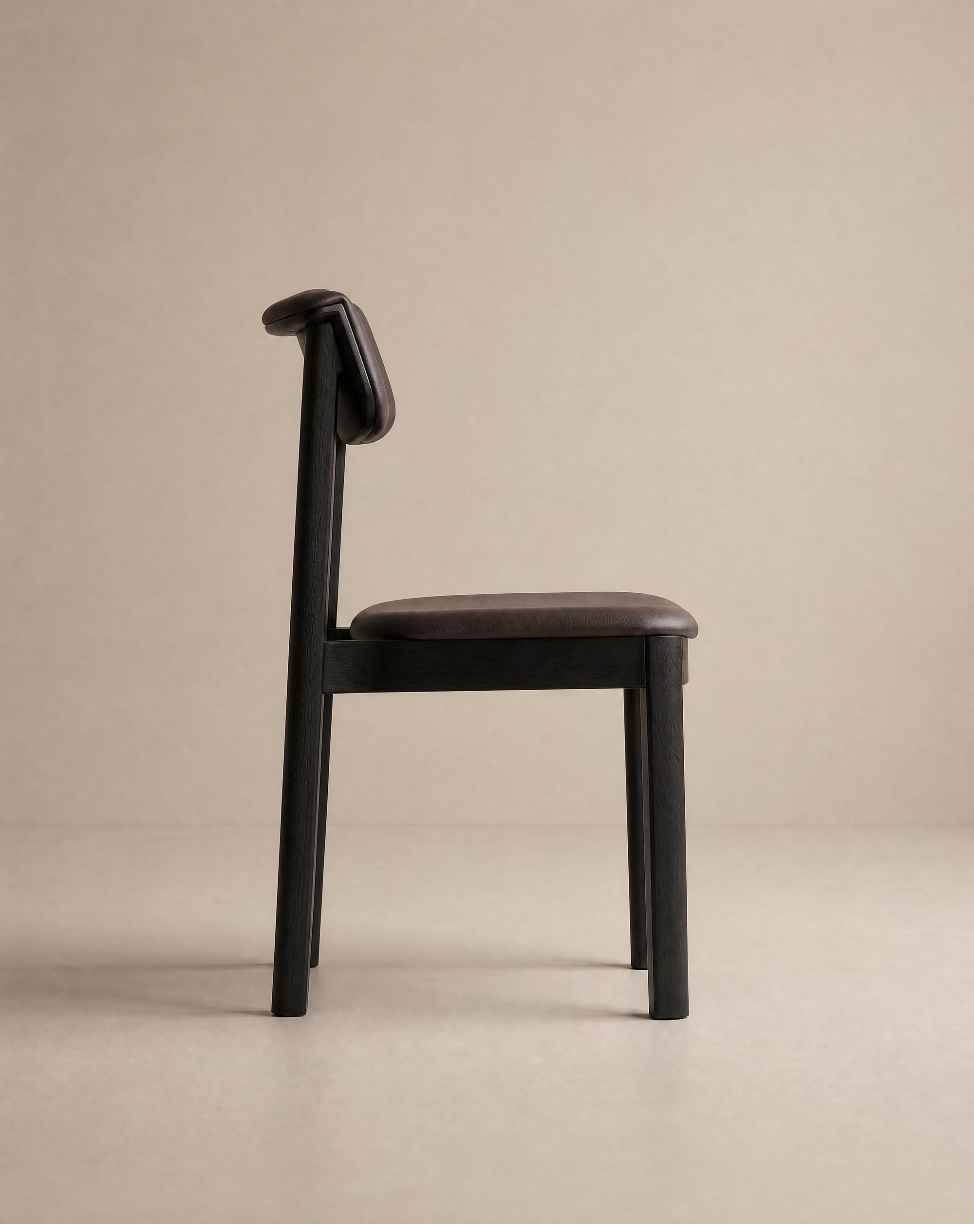 The Noki Dining Chair | Leather by Wooden Stories features a modern, minimalist design with a dark solid wood frame and brown leather seat and backrest—crafted to contract grade standards for lasting durability and style.