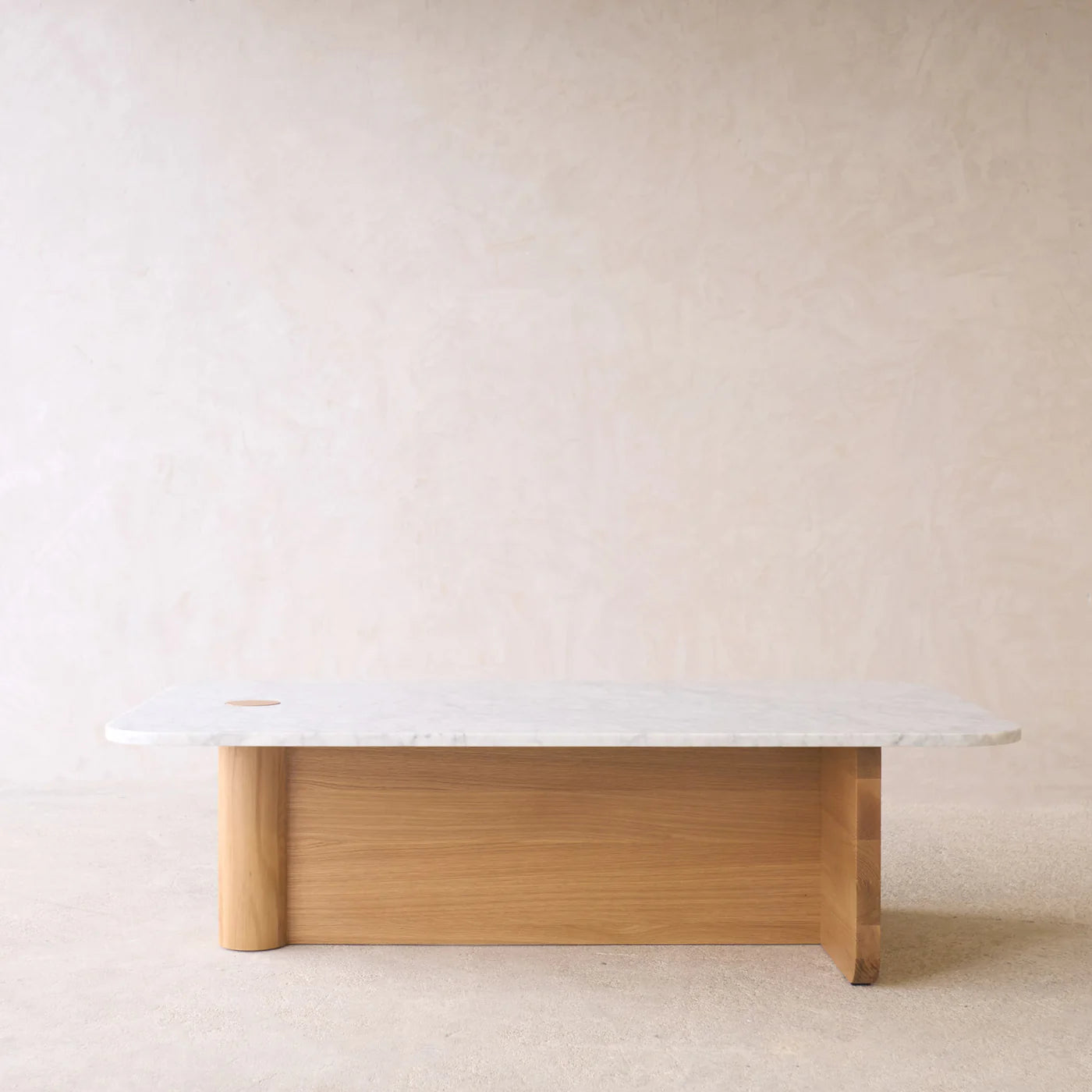 The Pivot Coffee Table | Rectangular - Stone & Wood by Wooden Stories features a white marble top and a solid wood base, styled against a neutral, textured wall and a light floor.