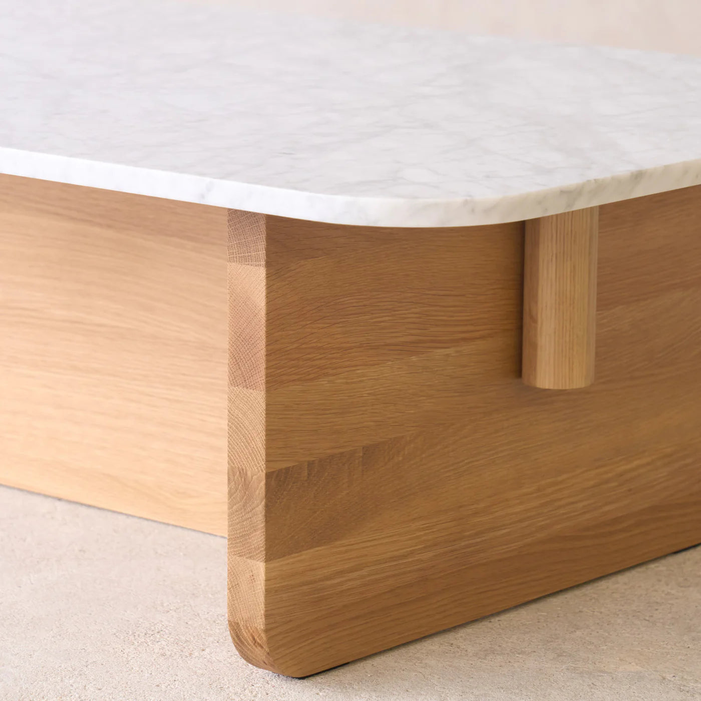 A close-up of the Wooden Stories Pivot Coffee Table | Rectangular shows its honed marble top and light solid wood dowel base, highlighting smooth edges and a clean, minimalist look.