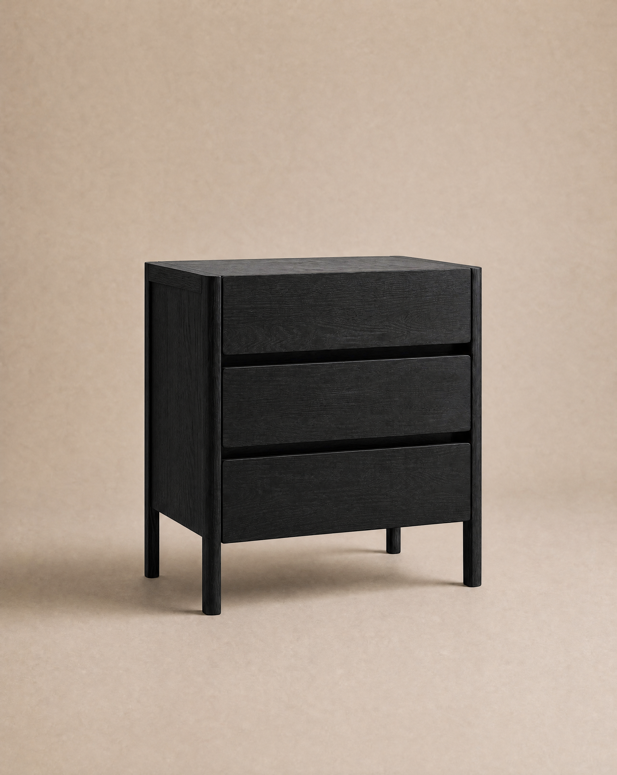 Introducing the Nell Tall Dresser by Wooden Stories—a sleek, modern black wooden dresser with three spacious drawers and premium metal runners for smooth operation, set against a plain beige background. Part of the exclusive Danish Collection, it’s the perfect enhancement to your bedroom storage.