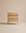 The Wooden Stories Nell Tall Dresser features a light wood finish and three spacious drawers, set against a plain beige background. Its minimalist and modern design is highlighted by clean lines, premium metal runners, and a smooth surface—making it the perfect choice for stylish bedroom storage.