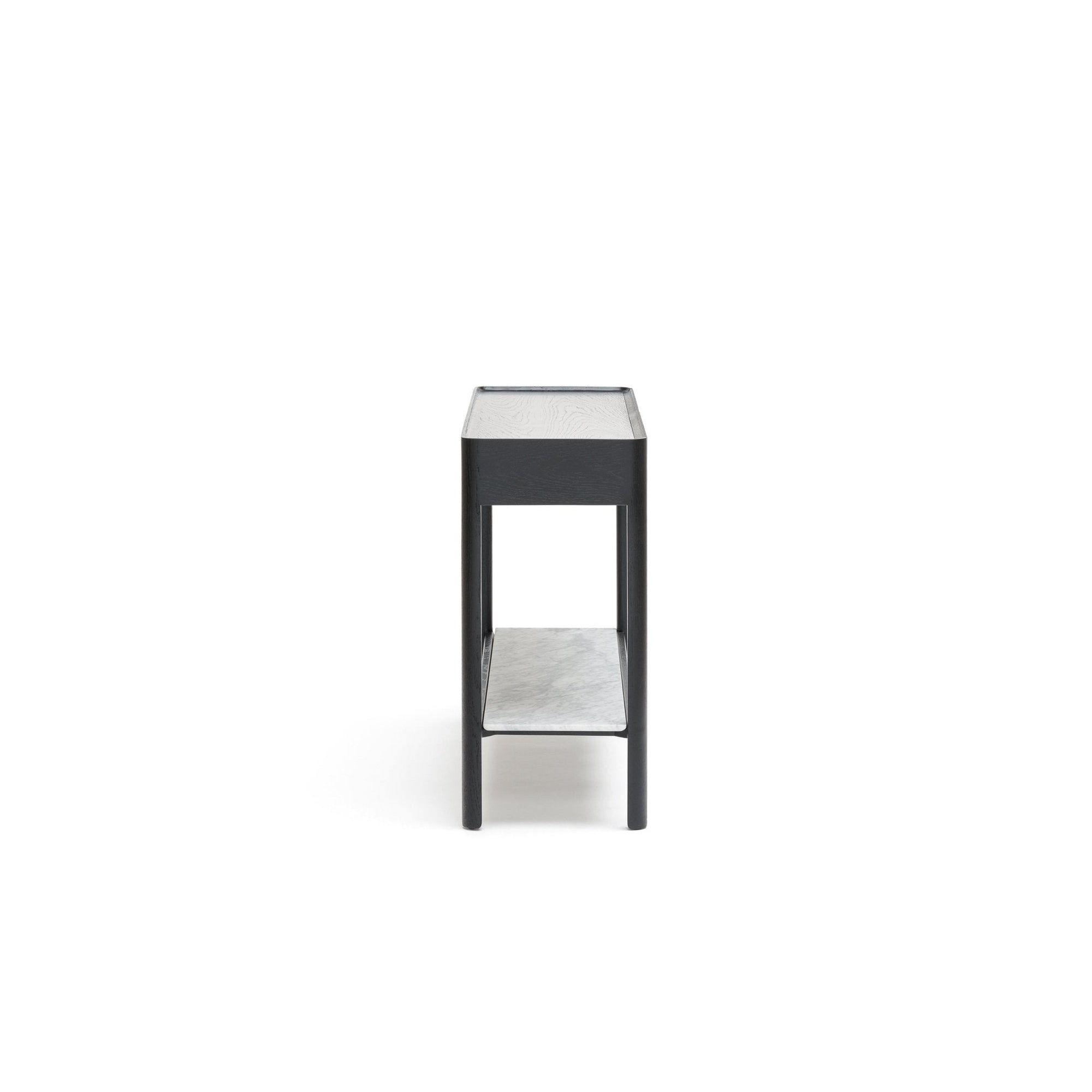 The Nell Console by Wooden Stories, shown in black oak with stone, features a rectangular silhouette and lower shelf. Photographed from the side on a white background, its clean lines highlight its minimalist Scandinavian design.